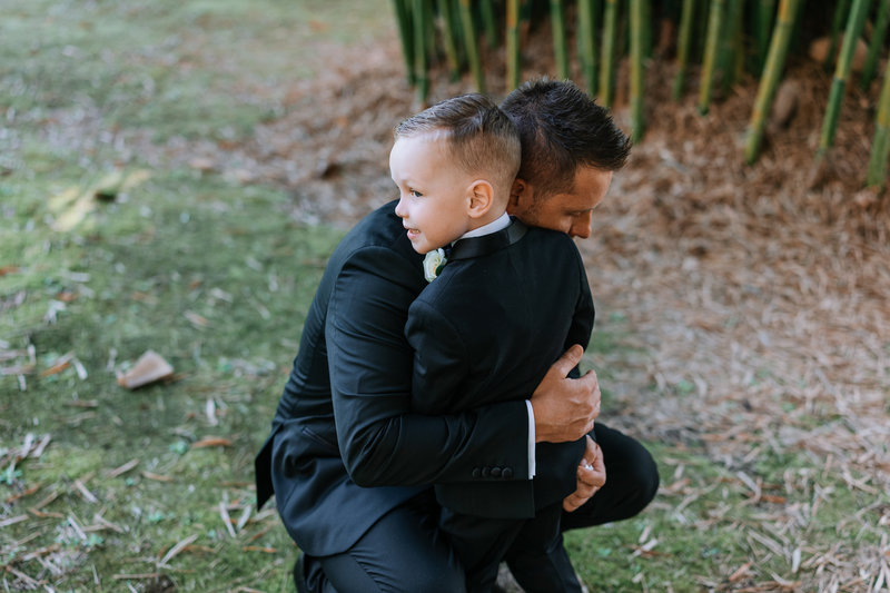 groom hugging four year old son at ceremony 